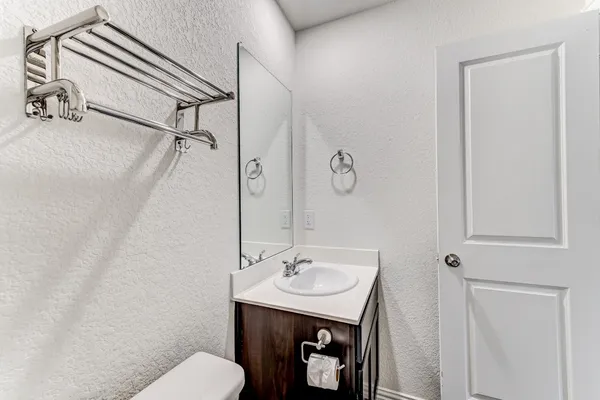 a bathroom with a toilet a sink and mirror