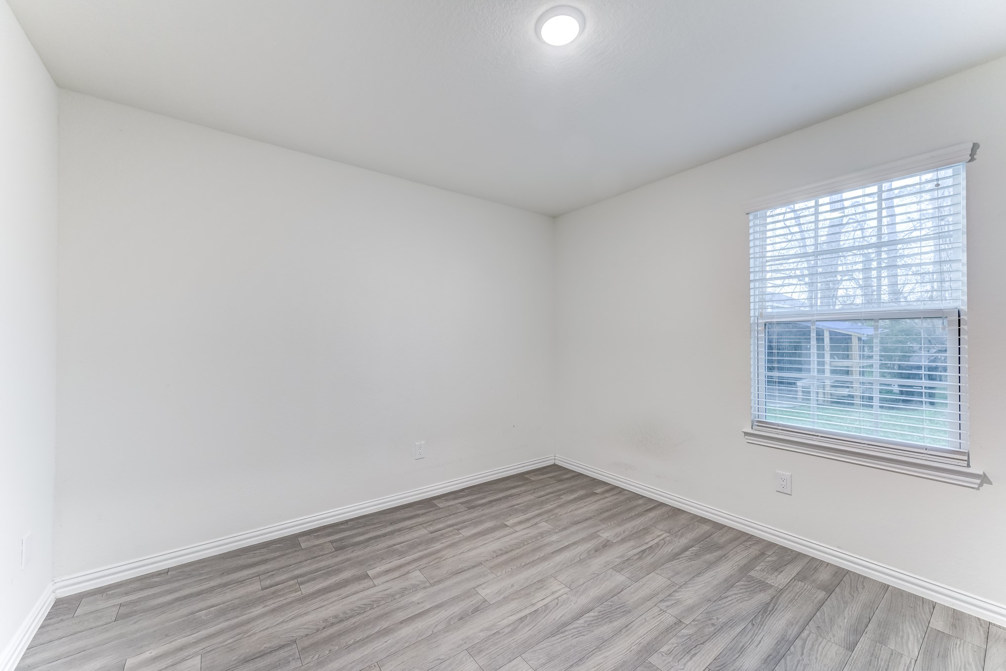 7925 Way Street, Unit A Houston, TX 77028 - Photo 23 of 29 an empty room with wooden floor and windows