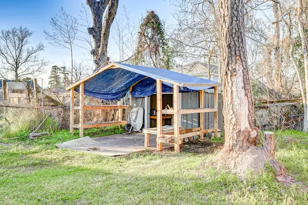 a view of a house with a yard balcony and wooden fence