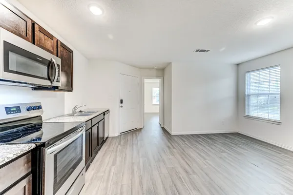 a kitchen with granite countertop wooden floors and stainless steel appliances