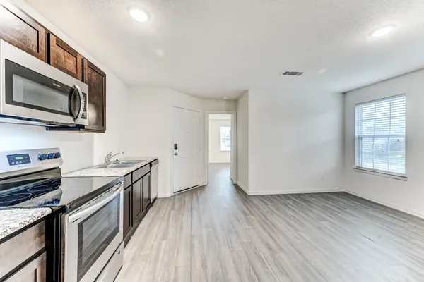 a kitchen with granite countertop wooden floors and stainless steel appliances