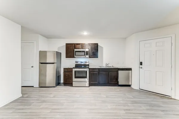a kitchen with stainless steel appliances granite countertop a refrigerator and a stove top oven