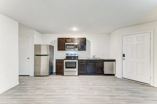 a kitchen with stainless steel appliances granite countertop a refrigerator and a stove top oven