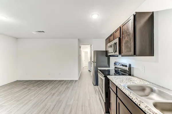 a kitchen with stainless steel appliances granite countertop a sink stove and refrigerator