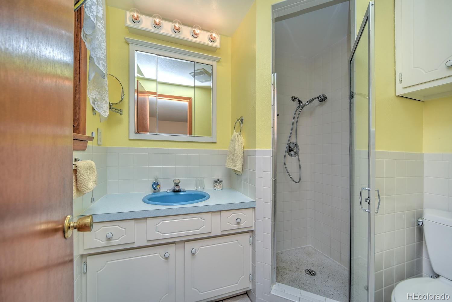2219 Riviera Place Longmont, CO 80501 - Photo 14 of 19 a bathroom with a granite countertop shower sink vanity and mirror