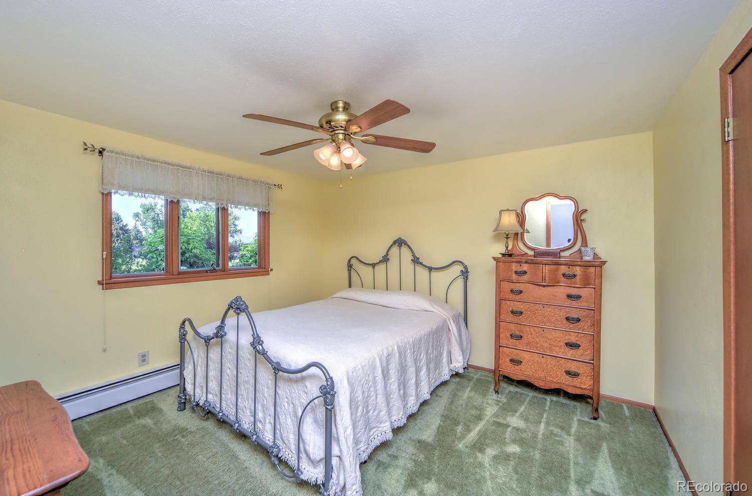 2219 Riviera Place Longmont, CO 80501 - Photo 15 of 19 a bedroom with a bed and a chandelier