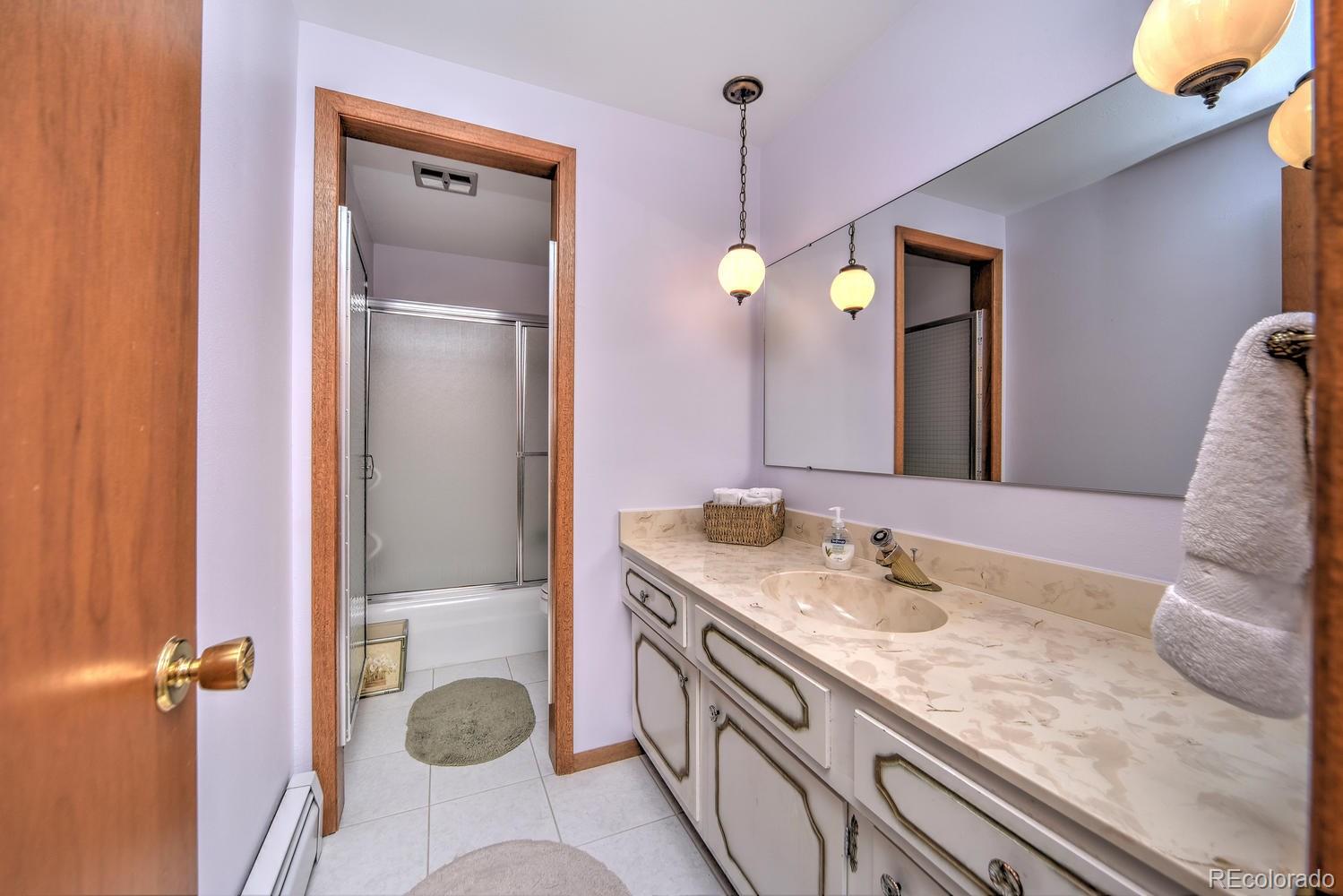 2219 Riviera Place Longmont, CO 80501 - Photo 17 of 19 a bathroom with a granite countertop sink and a mirror