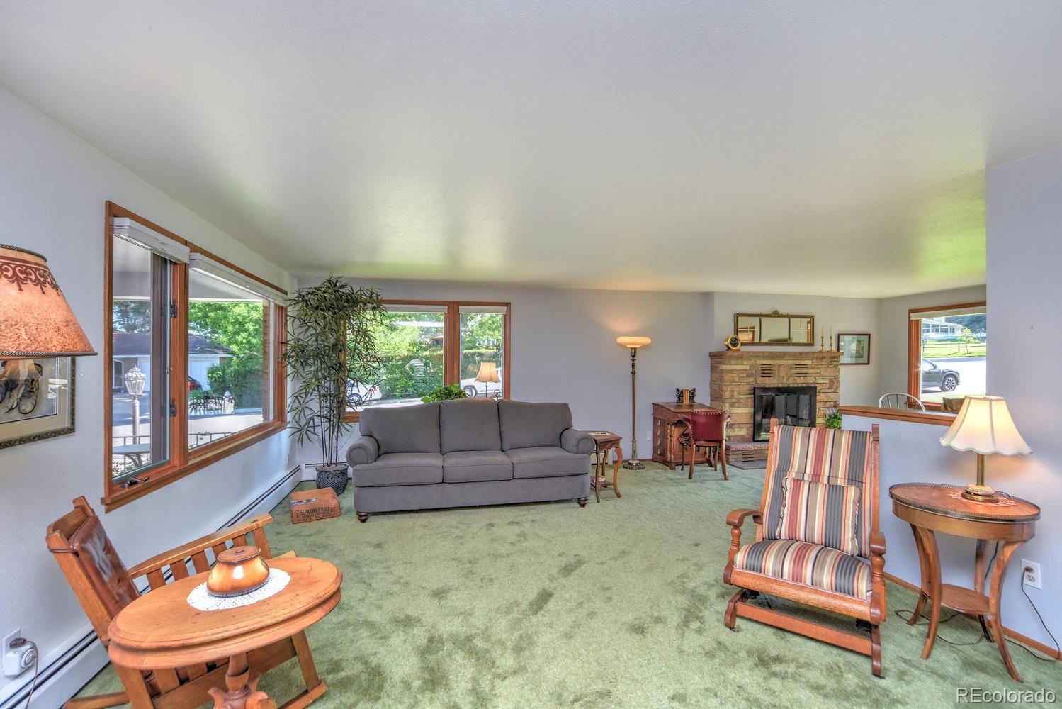 2219 Riviera Place Longmont, CO 80501 - Photo 3 of 19 a living room with furniture a fireplace and a large window