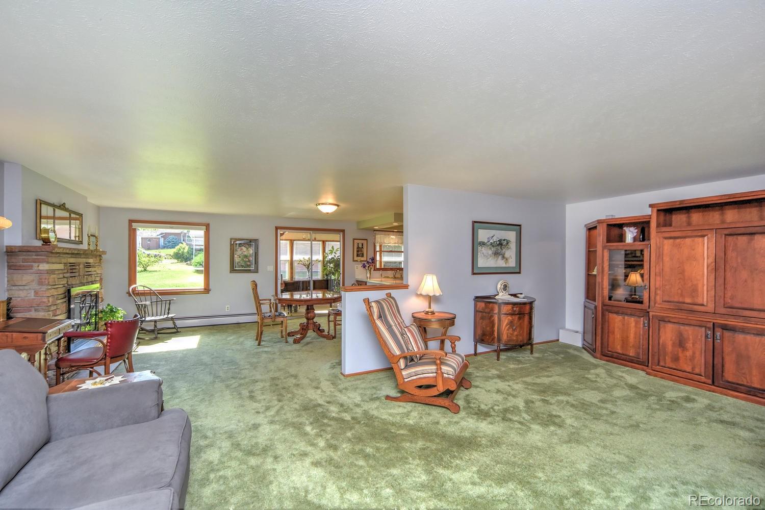 2219 Riviera Place Longmont, CO 80501 - Photo 4 of 19 a living room with furniture a dining table and wooden floor