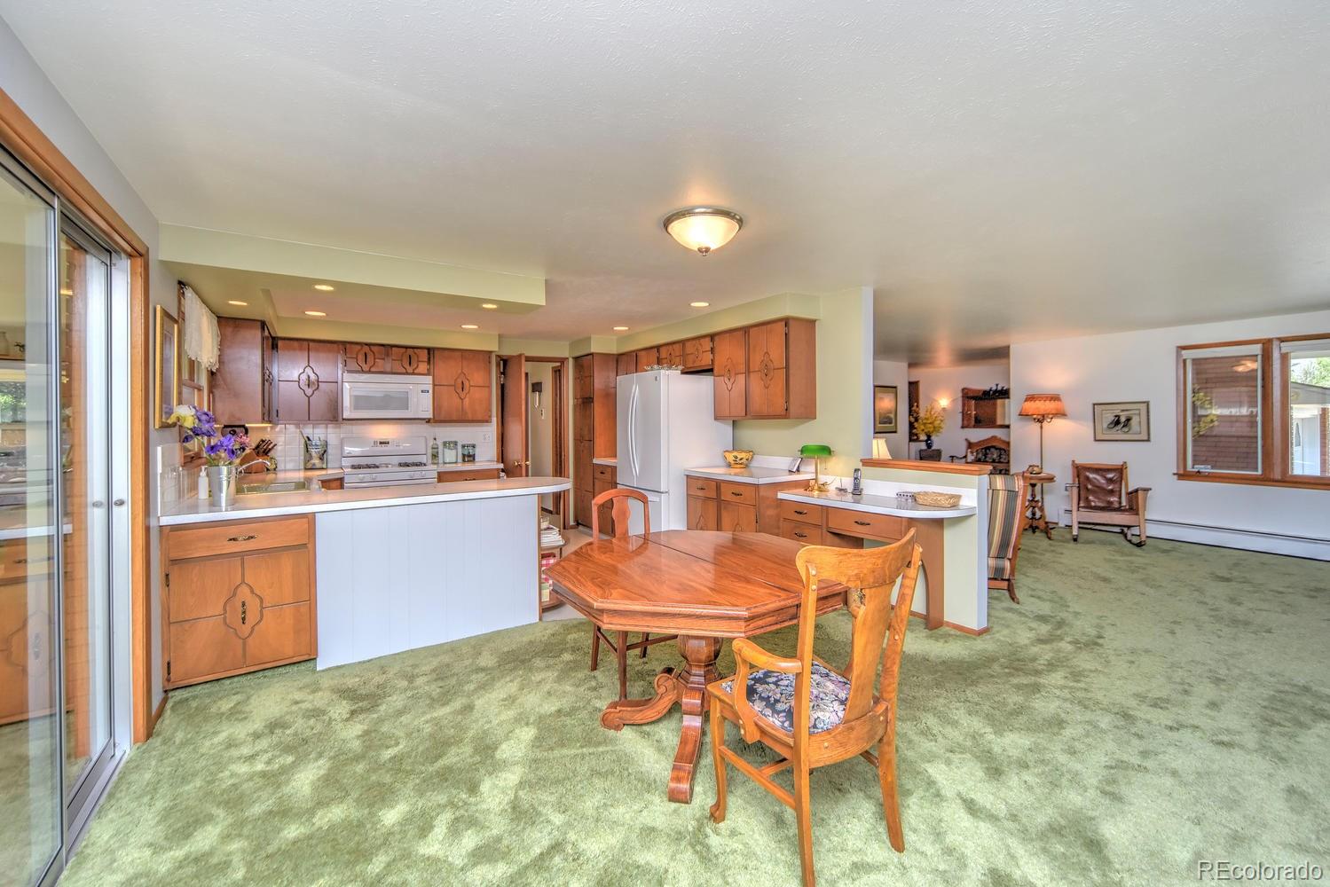 2219 Riviera Place Longmont, CO 80501 - Photo 6 of 19 a large kitchen with a table and chairs