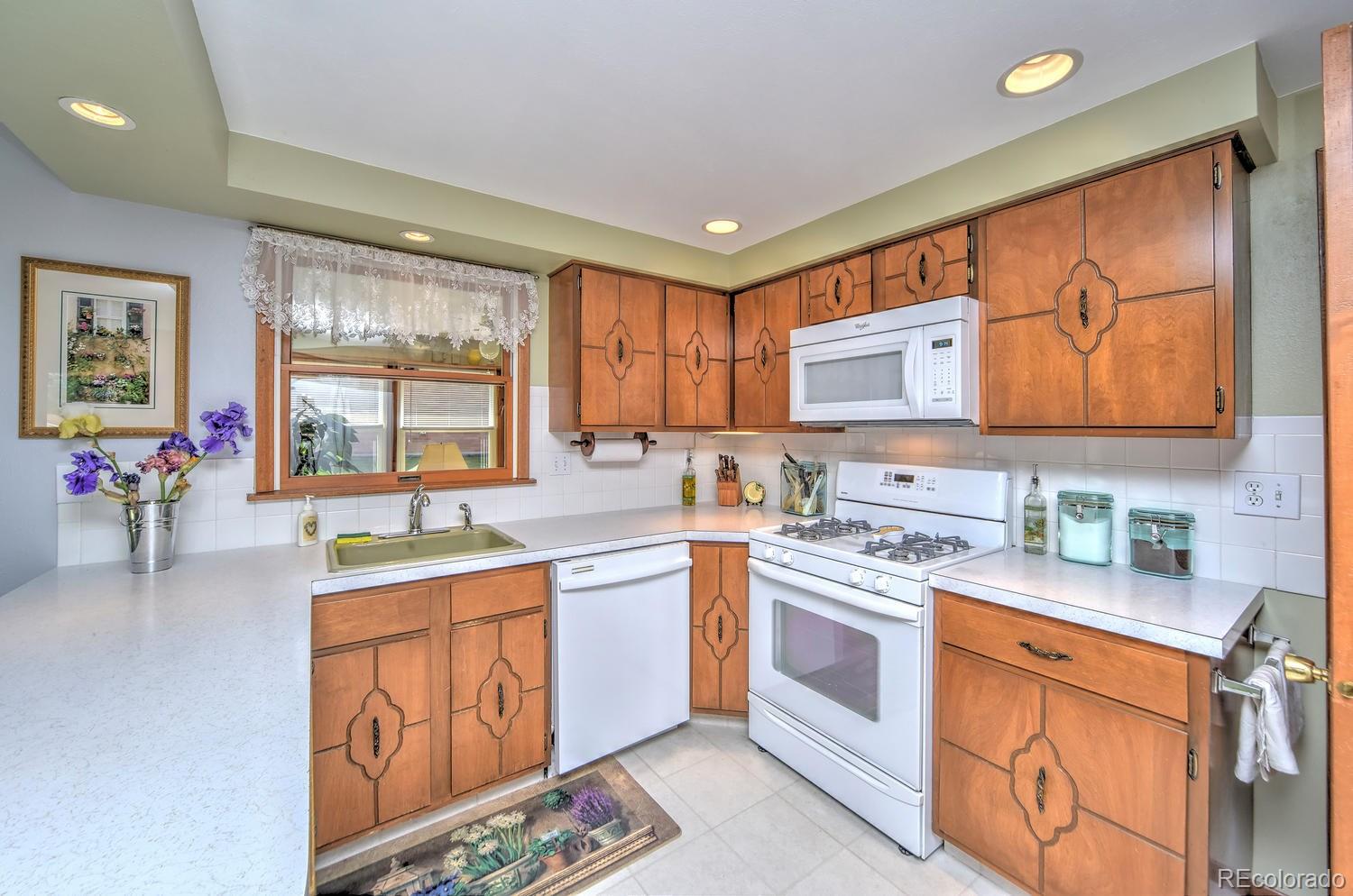 2219 Riviera Place Longmont, CO 80501 - Photo 8 of 19 a kitchen with stainless steel appliances granite countertop a stove sink and cabinets