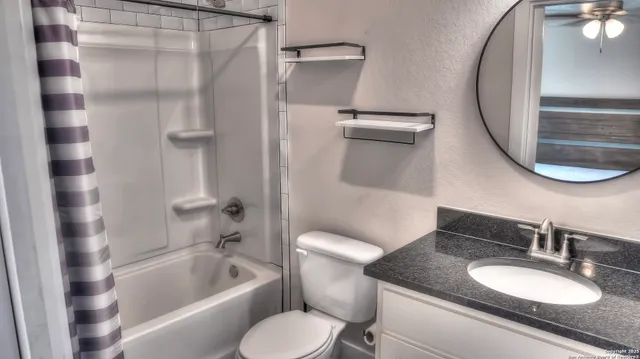 a white toilet sitting next to a small window