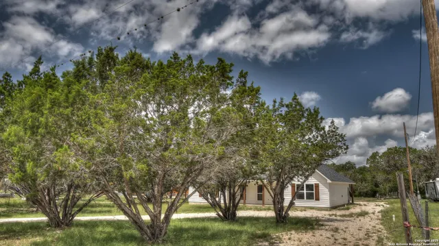 a front view of a house with a yard and trees