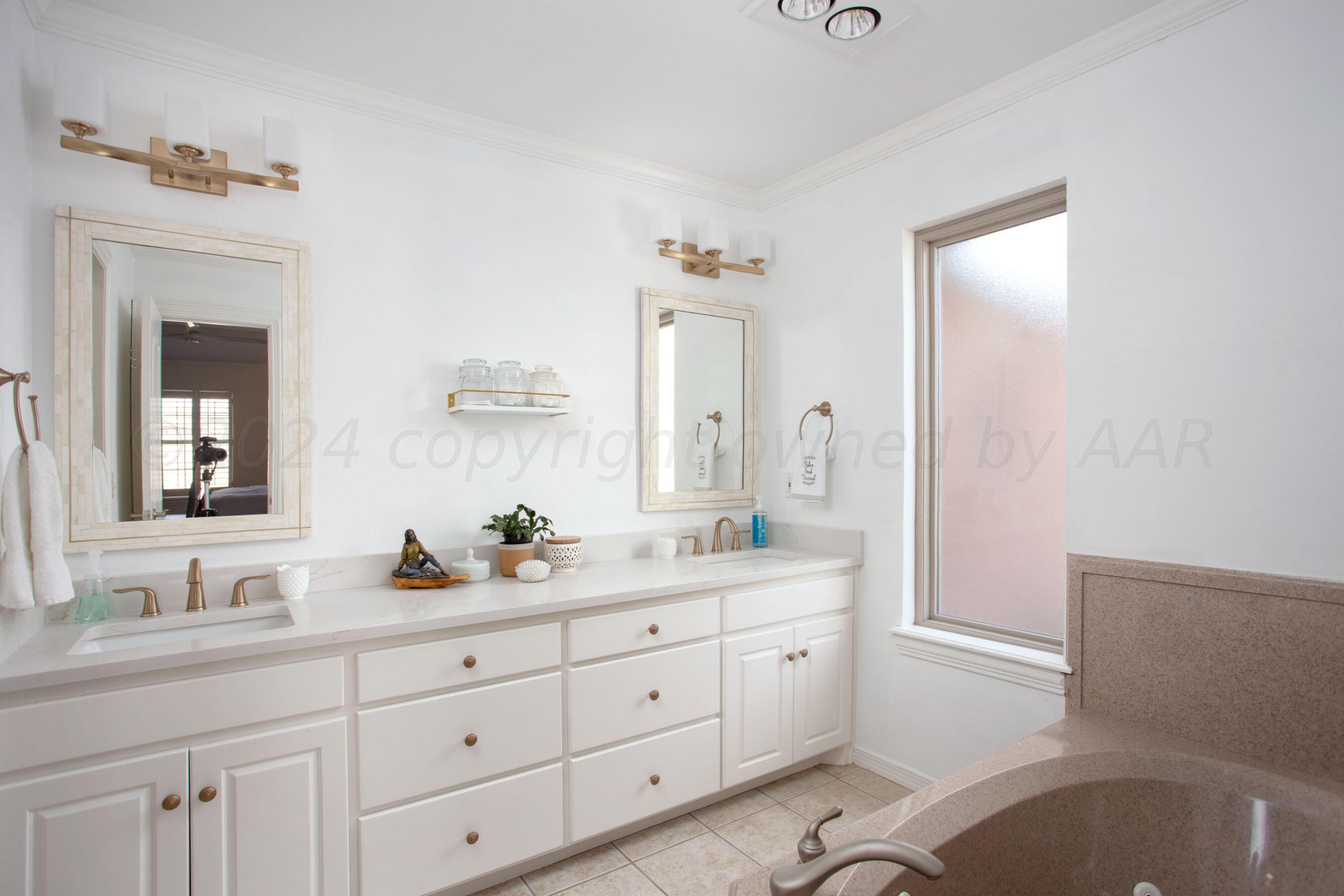 6921 Thunder Road Amarillo, TX 79119 - Photo 13 of 28 a spacious bathroom with a granite countertop sink and a mirror
