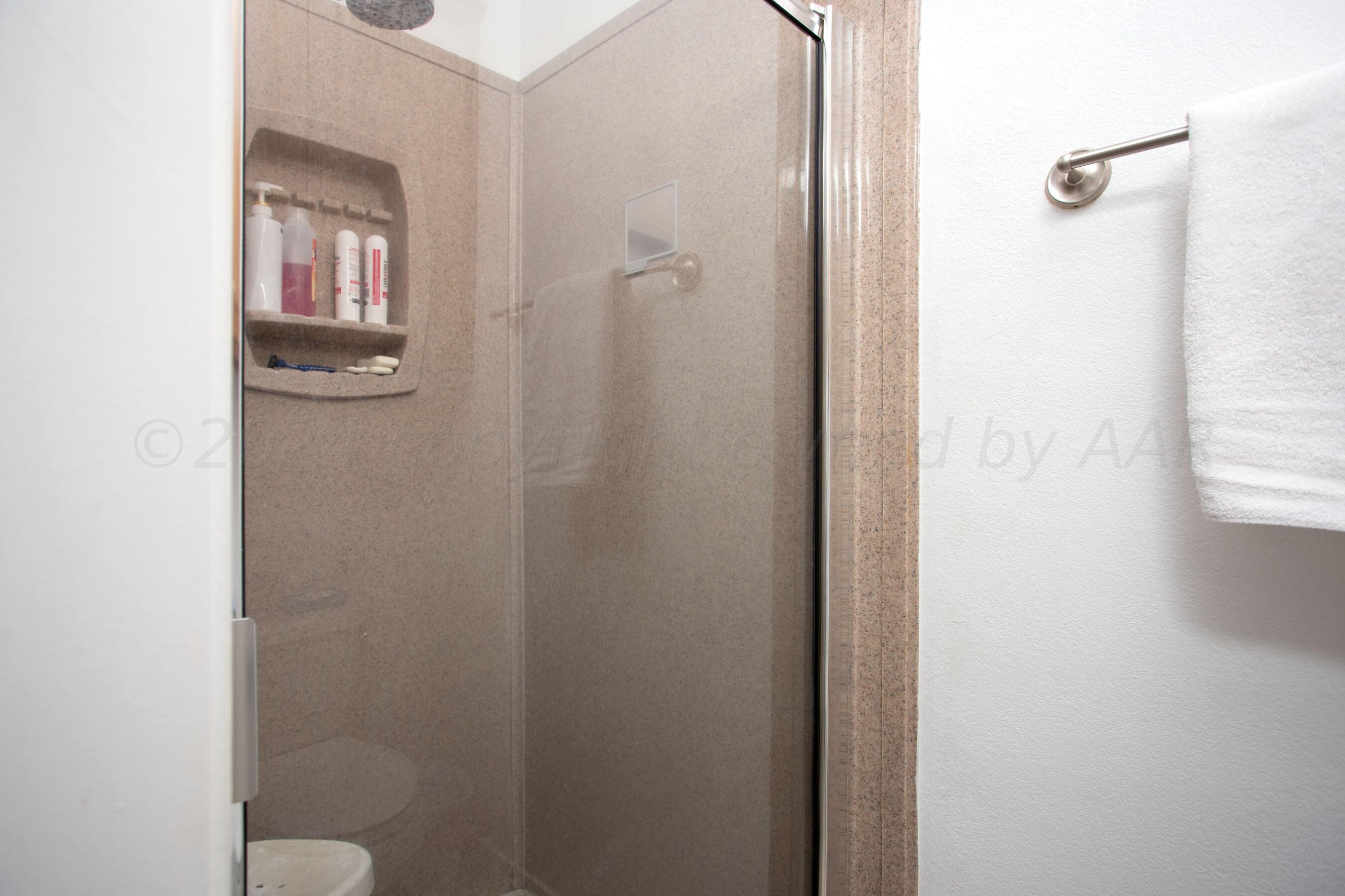 6921 Thunder Road Amarillo, TX 79119 - Photo 16 of 28 a bathroom with a granite countertop mirror and a sink