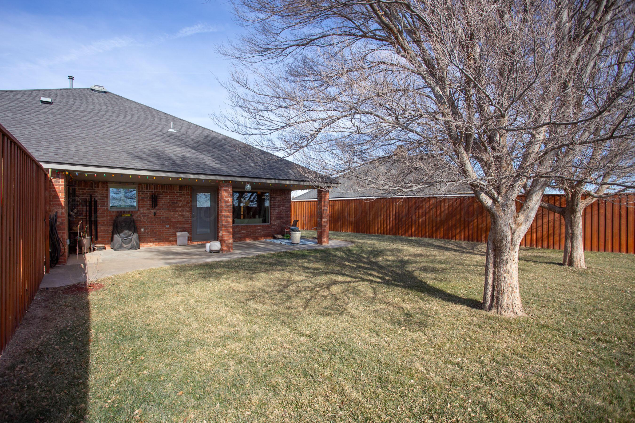 6921 Thunder Road Amarillo, TX 79119 - Photo 26 of 28 a view of a house with a large tree and wooden fence