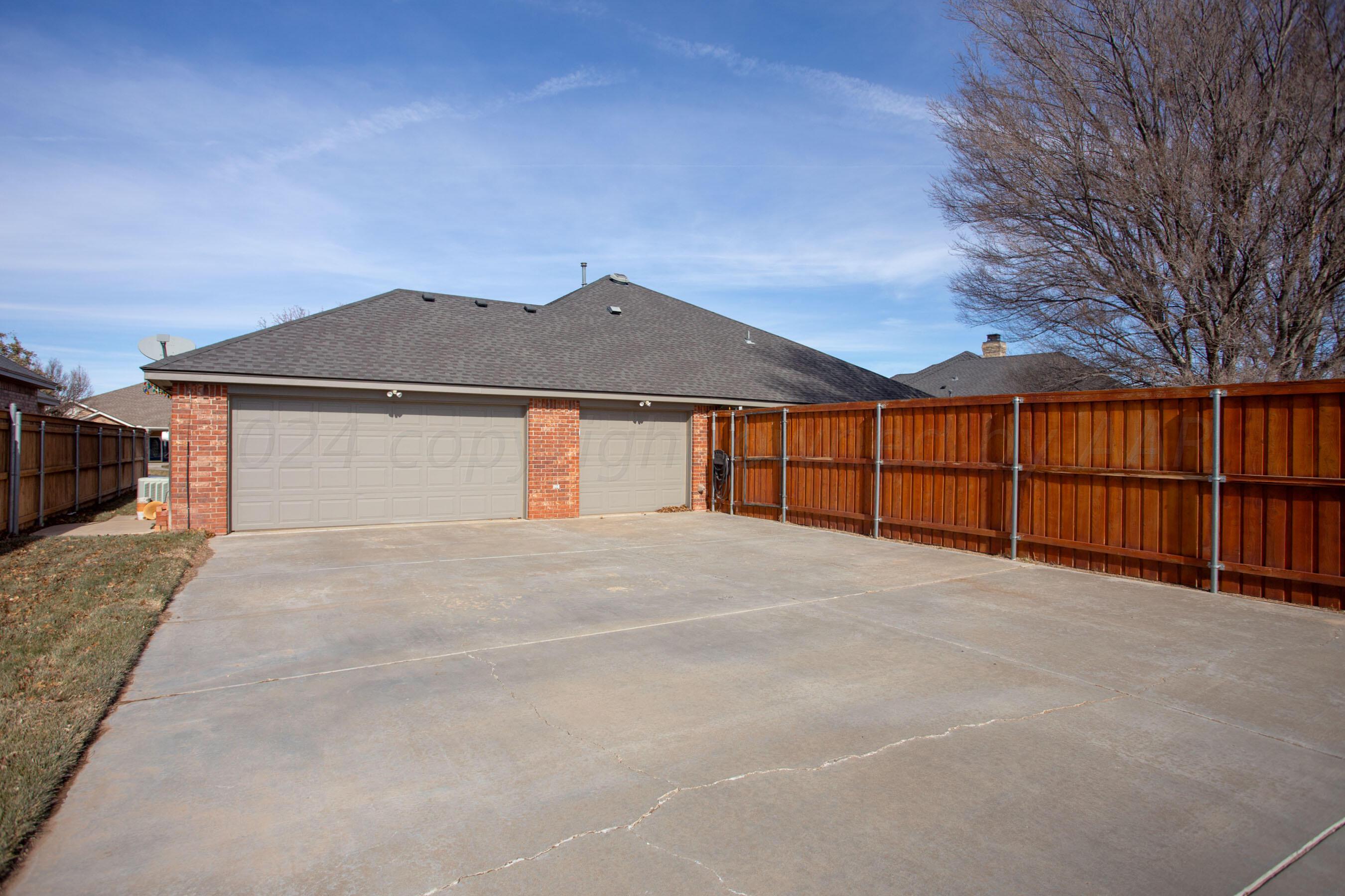 6921 Thunder Road Amarillo, TX 79119 - Photo 27 of 28 a view of a house with a yard and garage