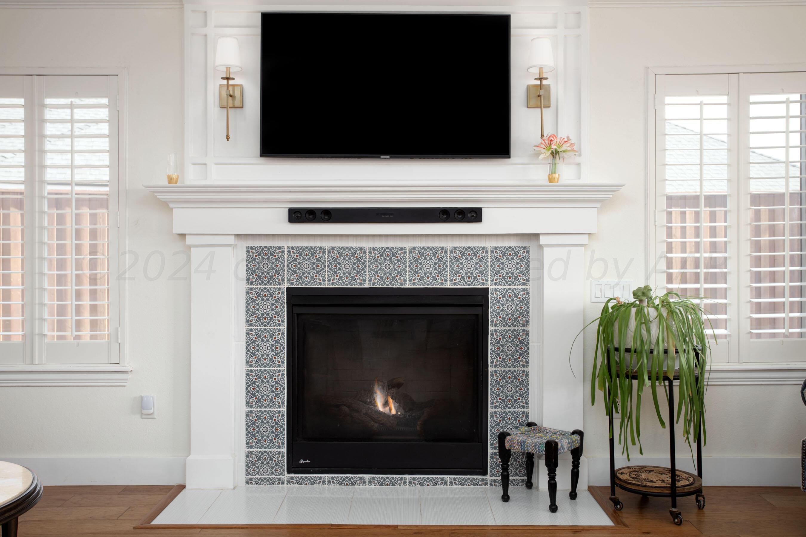 6921 Thunder Road Amarillo, TX 79119 - Photo 5 of 28 a living room with a fireplace and a flat screen tv