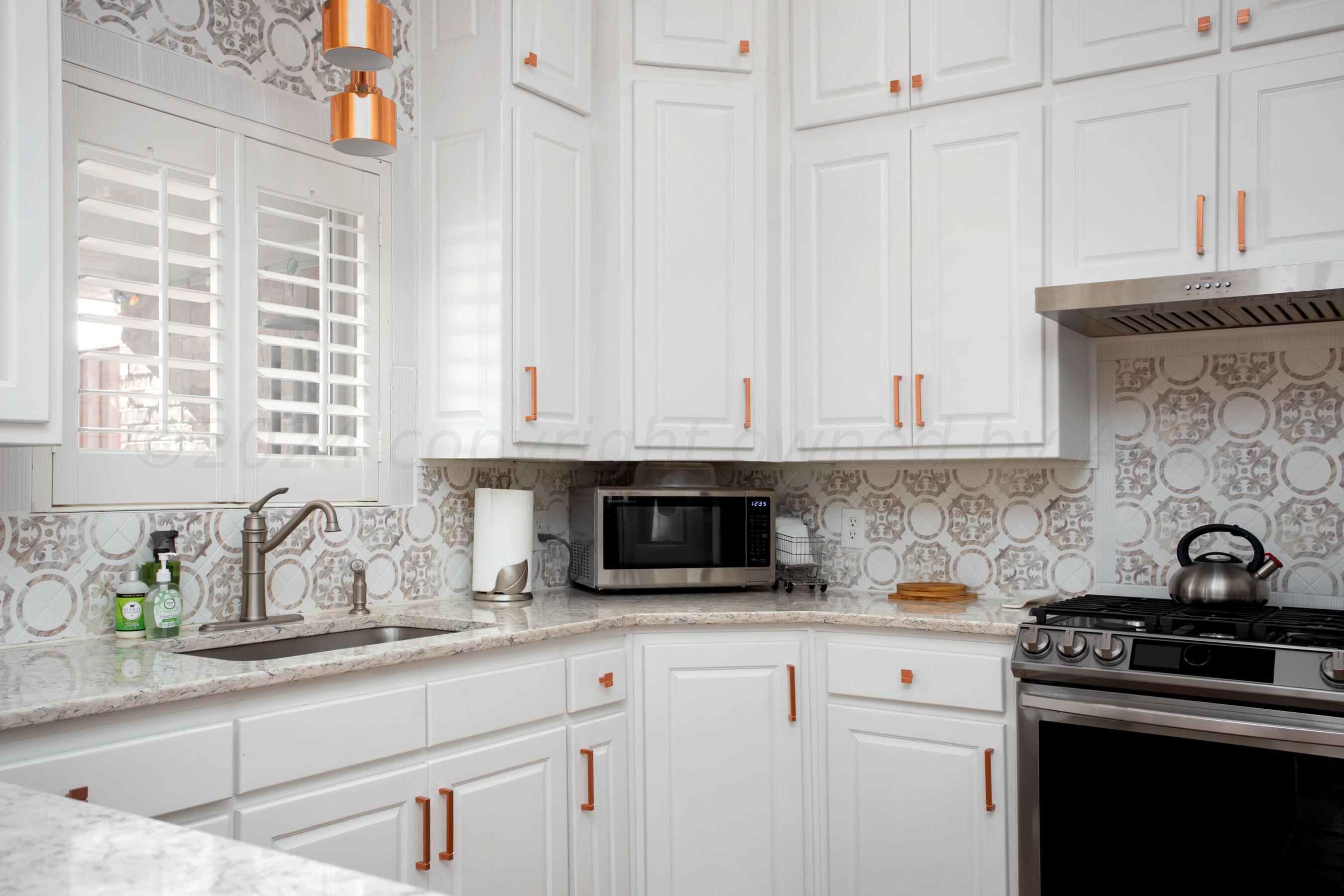 6921 Thunder Road Amarillo, TX 79119 - Photo 7 of 28 a kitchen with stainless steel appliances granite countertop white cabinets and a stove