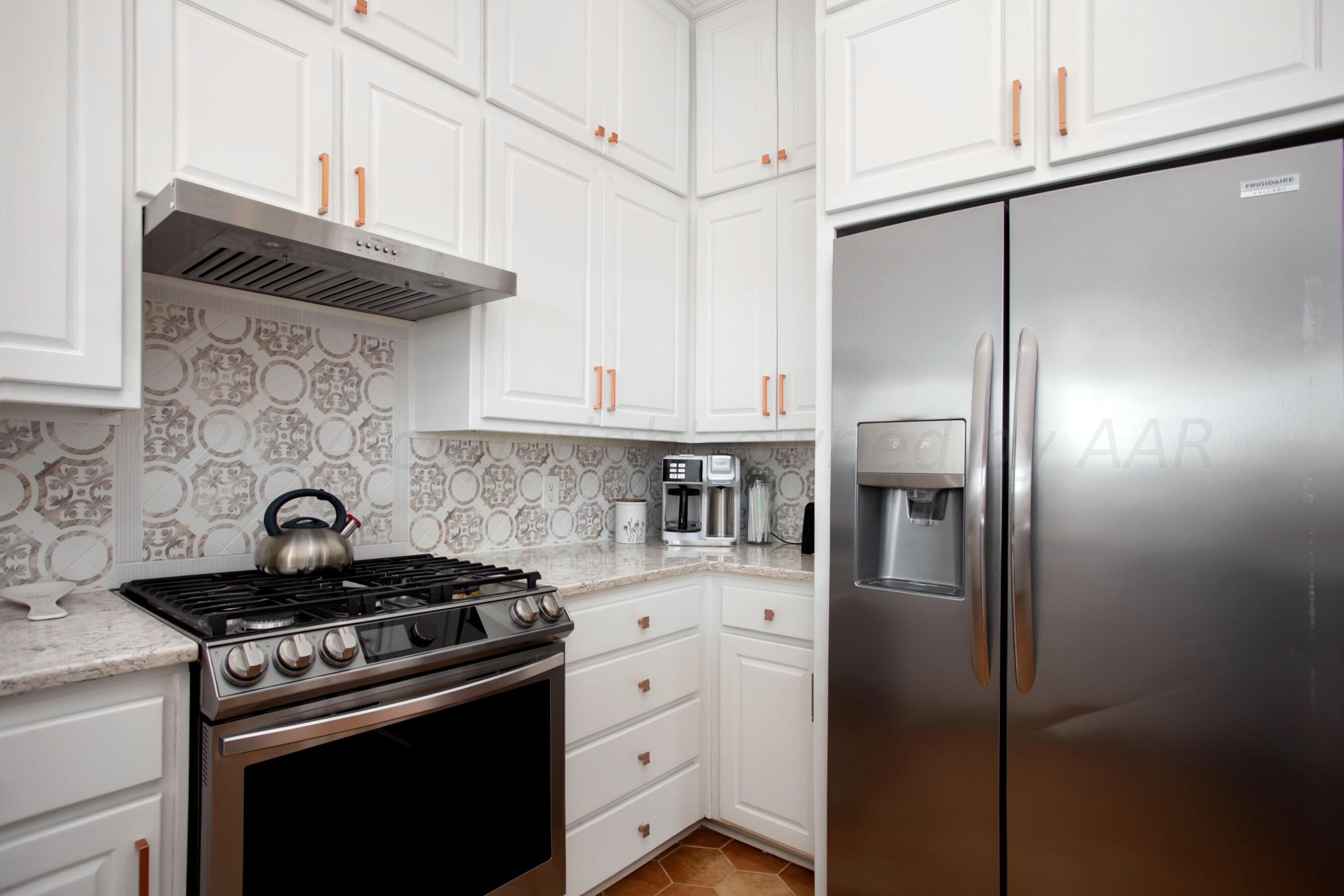 6921 Thunder Road Amarillo, TX 79119 - Photo 8 of 28 a kitchen with stainless steel appliances granite countertop a stove a refrigerator and a cabinets