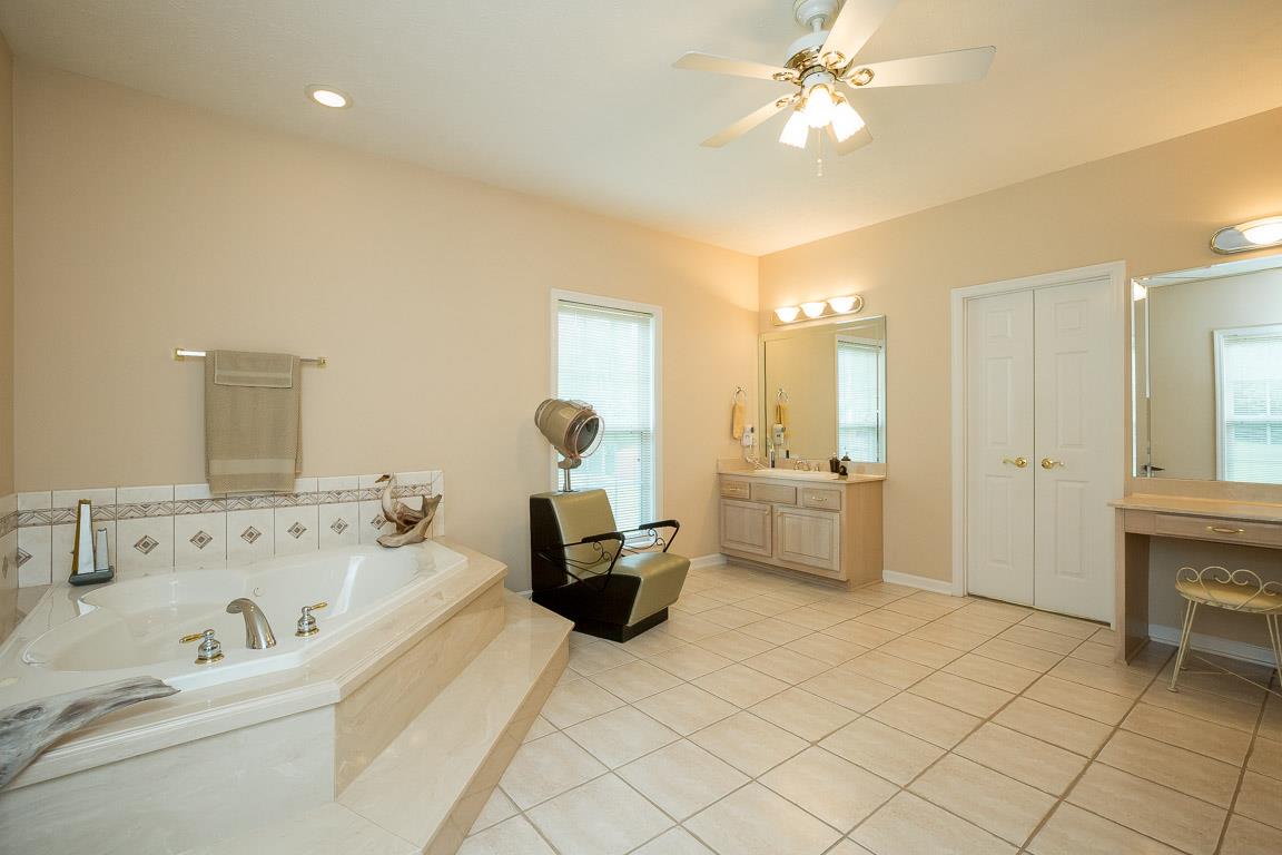 1066 Harkreader Road Mount Juliet, TN 37122 - Photo 24 of 30 a spacious bedroom with a bed a table and a chandelier