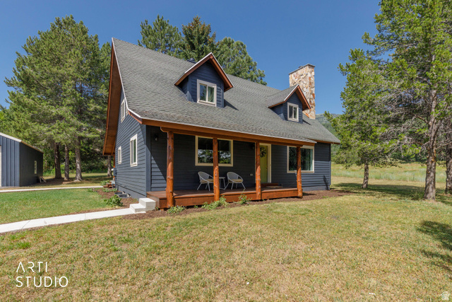 2807 North Ogden Canyon Road Eden, UT 84310 - Photo 3 of 72 Charming residence featuring dark blue siding, a covered front porch with natural wood posts, and a prominent stone chimney