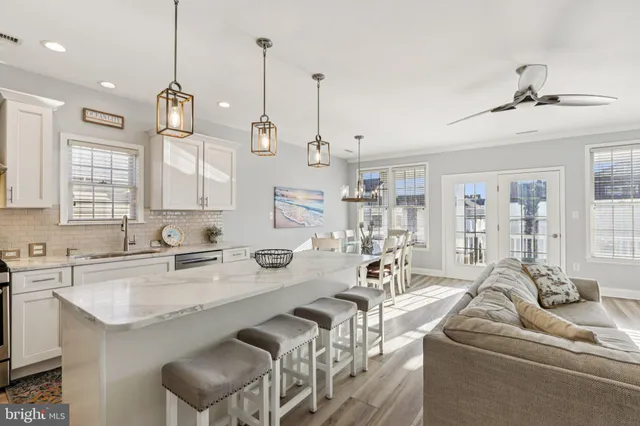 a open kitchen with stainless steel appliances granite countertop a sink a stove a refrigerator and island with wooden floor