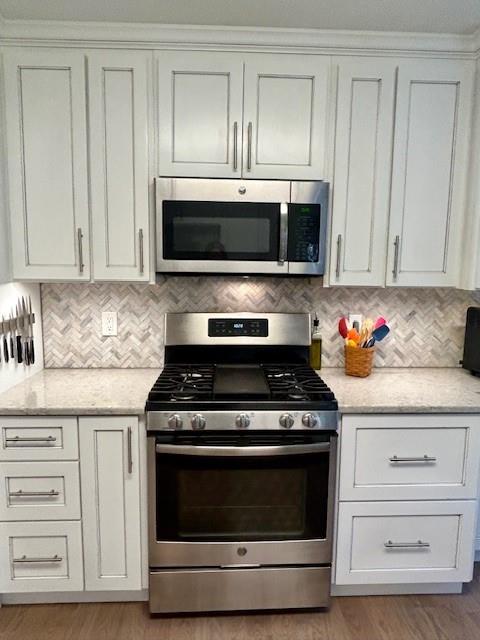 140 Washington Street Southeast Calhoun, GA 30701 - Photo 11 of 24 a kitchen with granite countertop white cabinets and stainless steel appliances