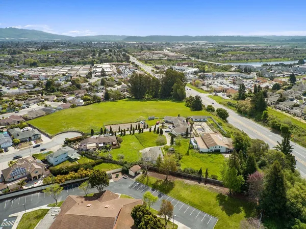 an aerial view of a city with lots of residential buildings and mountain view in back