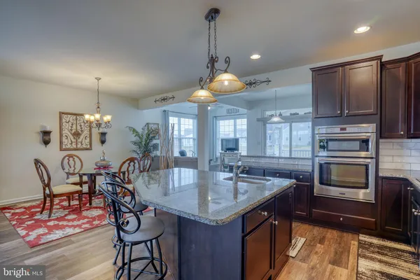 a kitchen with stainless steel appliances granite countertop a sink a stove and a refrigerator