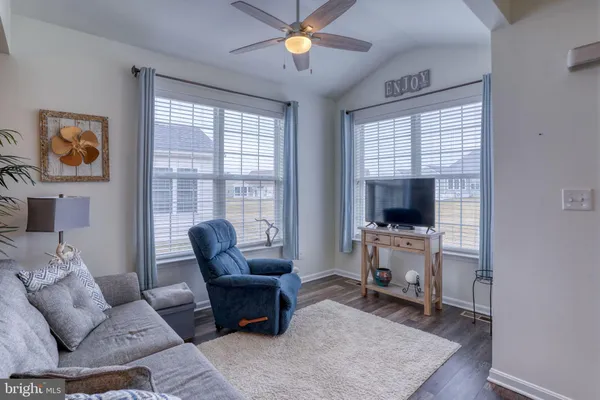a living room with furniture a flat screen tv and a window