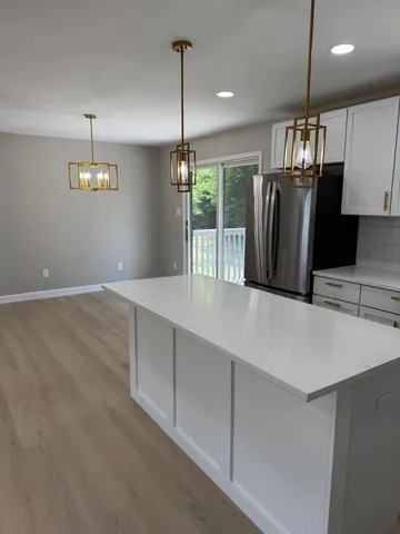 a view of a kitchen with a sink and dishwasher a refrigerator with wooden floor