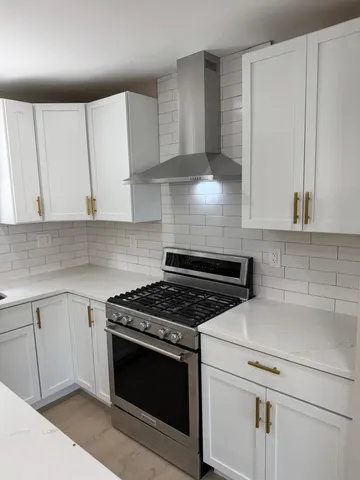 a kitchen with granite countertop white cabinets and white appliances