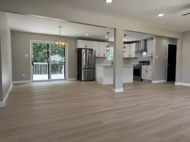 a view of a kitchen with refrigerator and wooden floor
