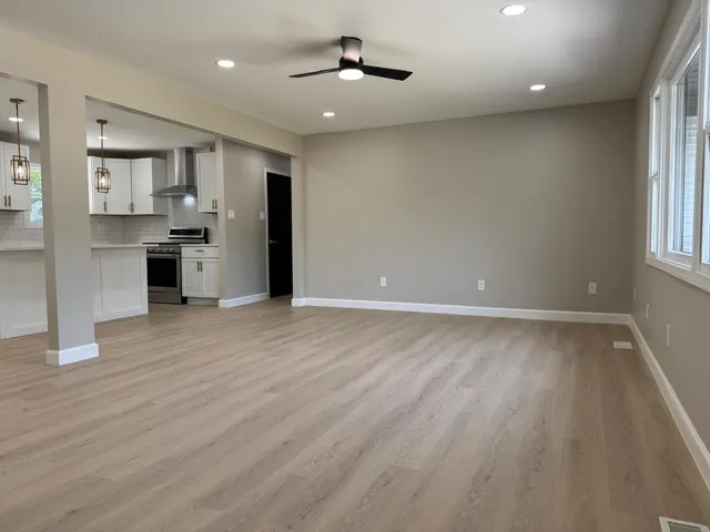 wooden floor in an empty room with a kitchen