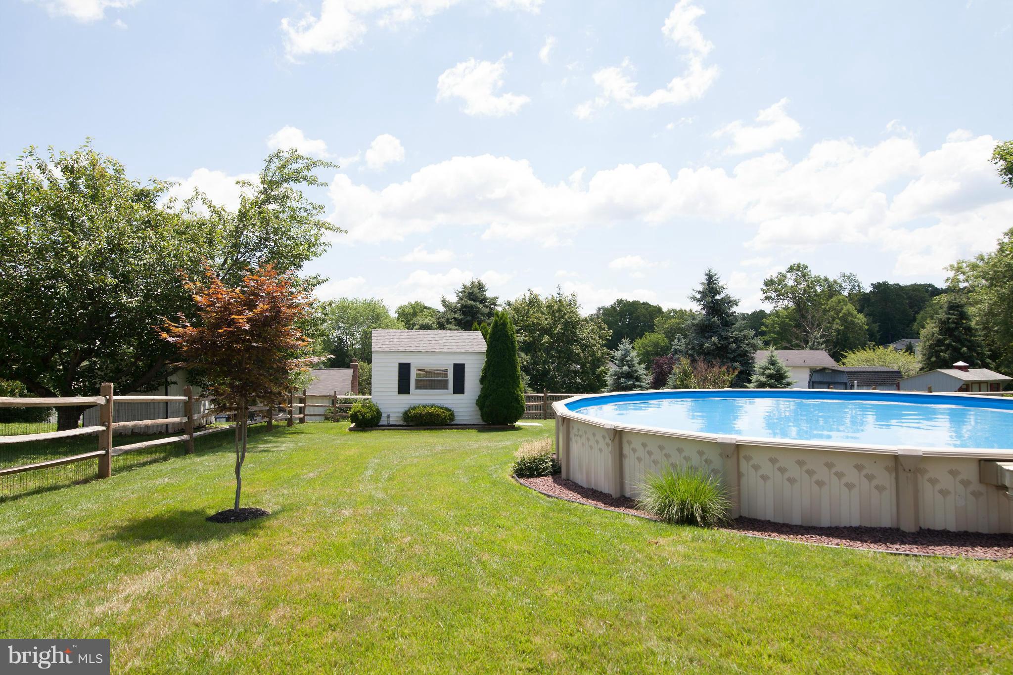 6151 Oklahoma Road Sykesville, MD 21784 - Photo 17 of 23 a view of a swimming pool with a bench and trees in the background