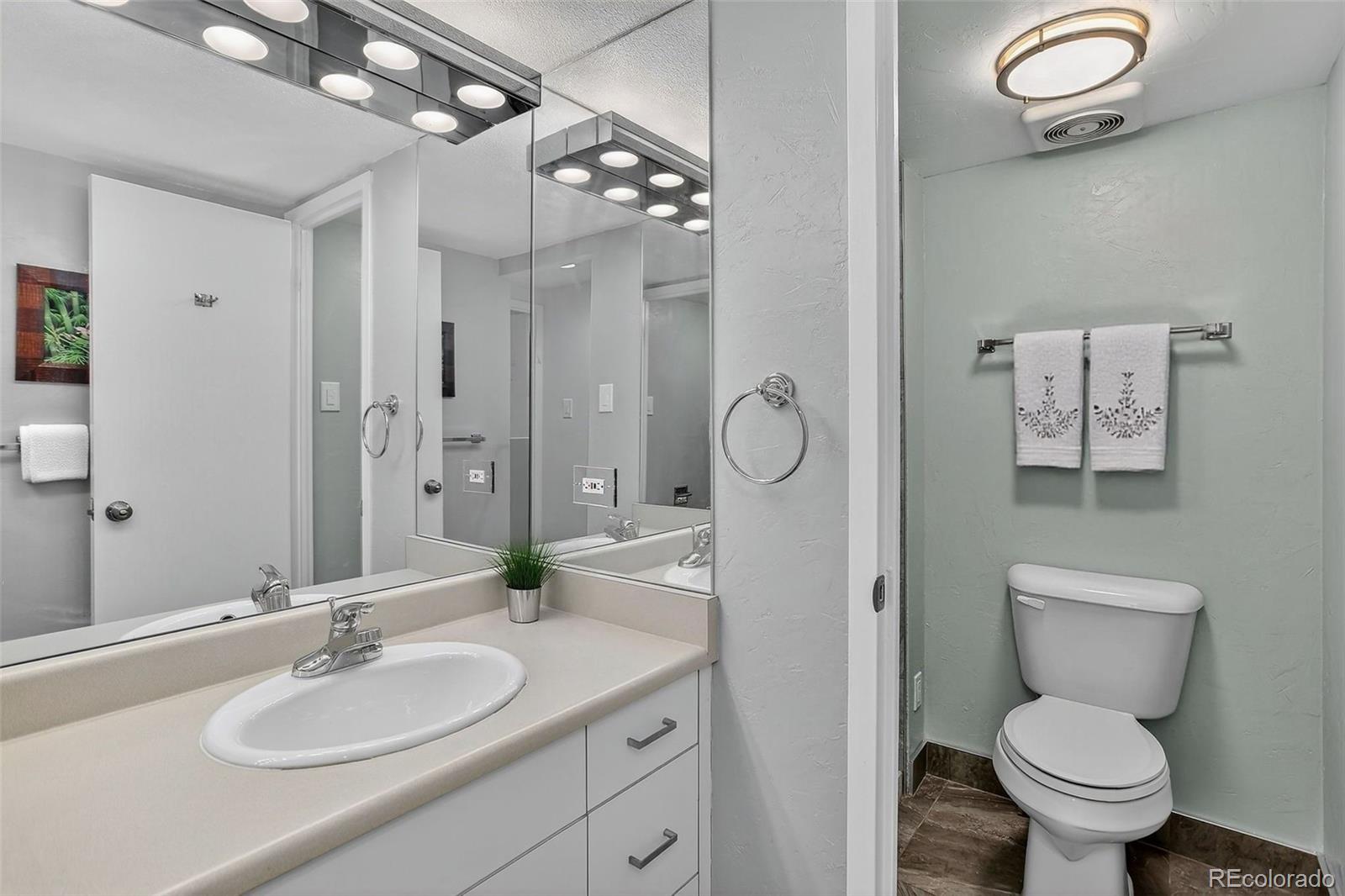 955 Eudora Street, Unit 1601 Denver, CO 80220 - Photo 13 of 36 a bathroom with a toilet sink a mirror and vanity