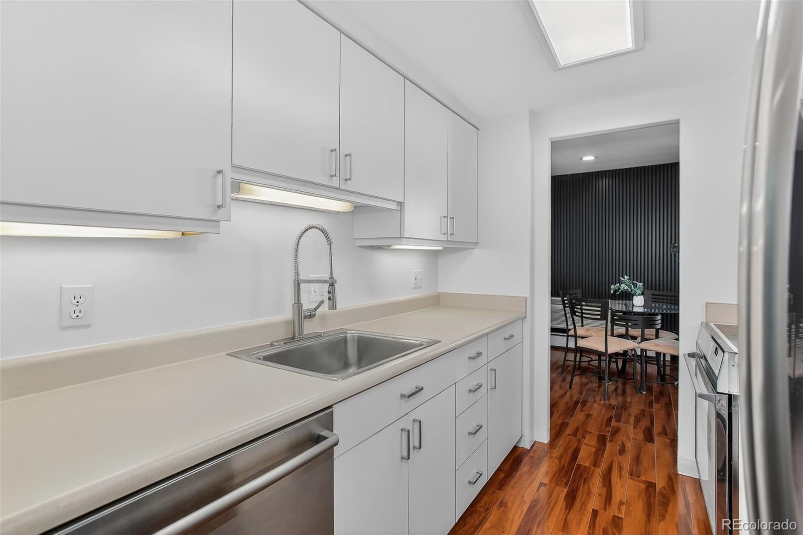 955 Eudora Street, Unit 1601 Denver, CO 80220 - Photo 10 of 36 a kitchen with sink cabinets and wooden floor