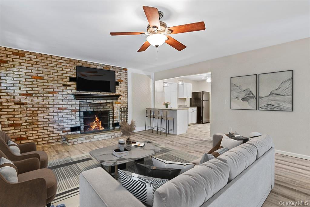 68 Gerald Drive, Unit D1 Poughkeepsie, NY 12601 - Photo 5 of 29 Living area with ceiling fan, a brick fireplace, light wood-style floors, and brick wall