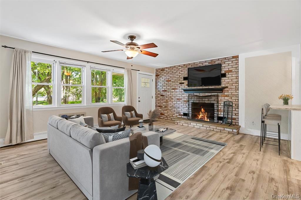 68 Gerald Drive, Unit D1 Poughkeepsie, NY 12601 - Photo 6 of 29 Living room featuring a fireplace, light wood-style flooring, and a ceiling fan