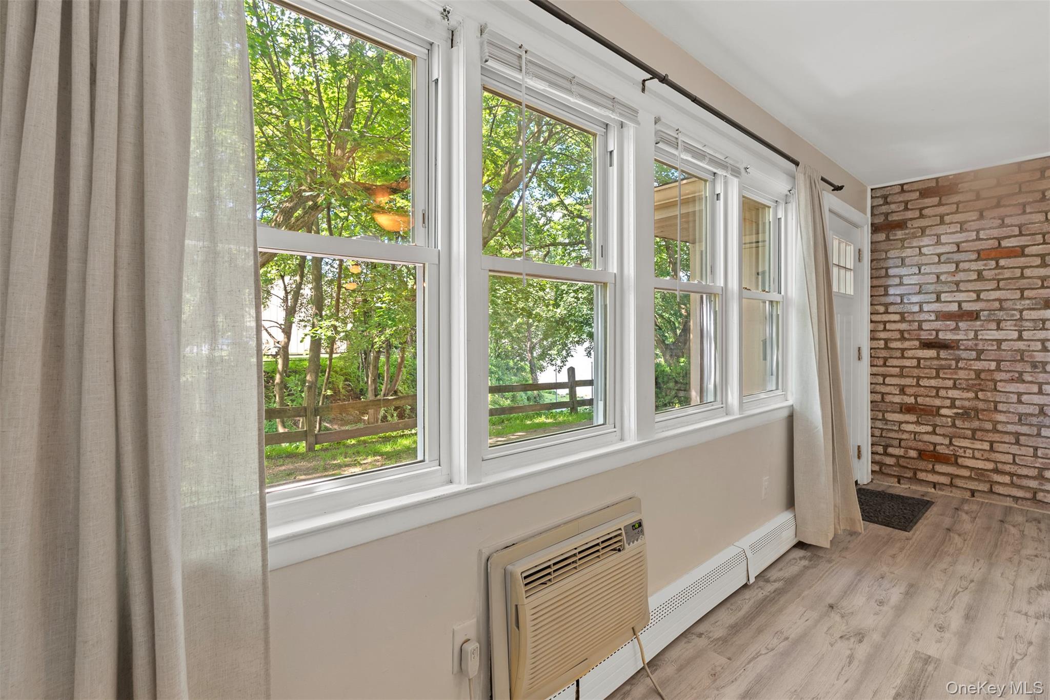 68 Gerald Drive, Unit D1 Poughkeepsie, NY 12601 - Photo 8 of 29 Unfurnished sunroom with brick wall, healthy amount of natural light, wood finished floors, and a wall mounted air conditioner