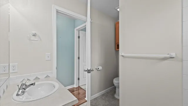 a bathroom with a sink a toilet and shower
