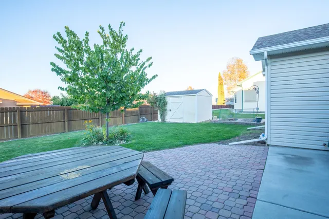 a view of a house with a backyard and a tree