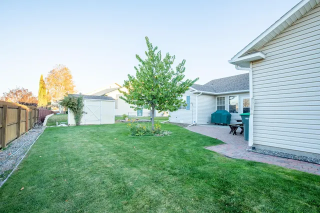 a view of a house with a yard and large tree