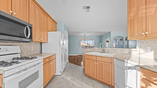 a kitchen with kitchen island granite countertop a sink stove and refrigerator