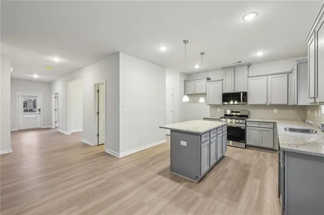 a kitchen with stainless steel appliances granite countertop a stove top oven and cabinets