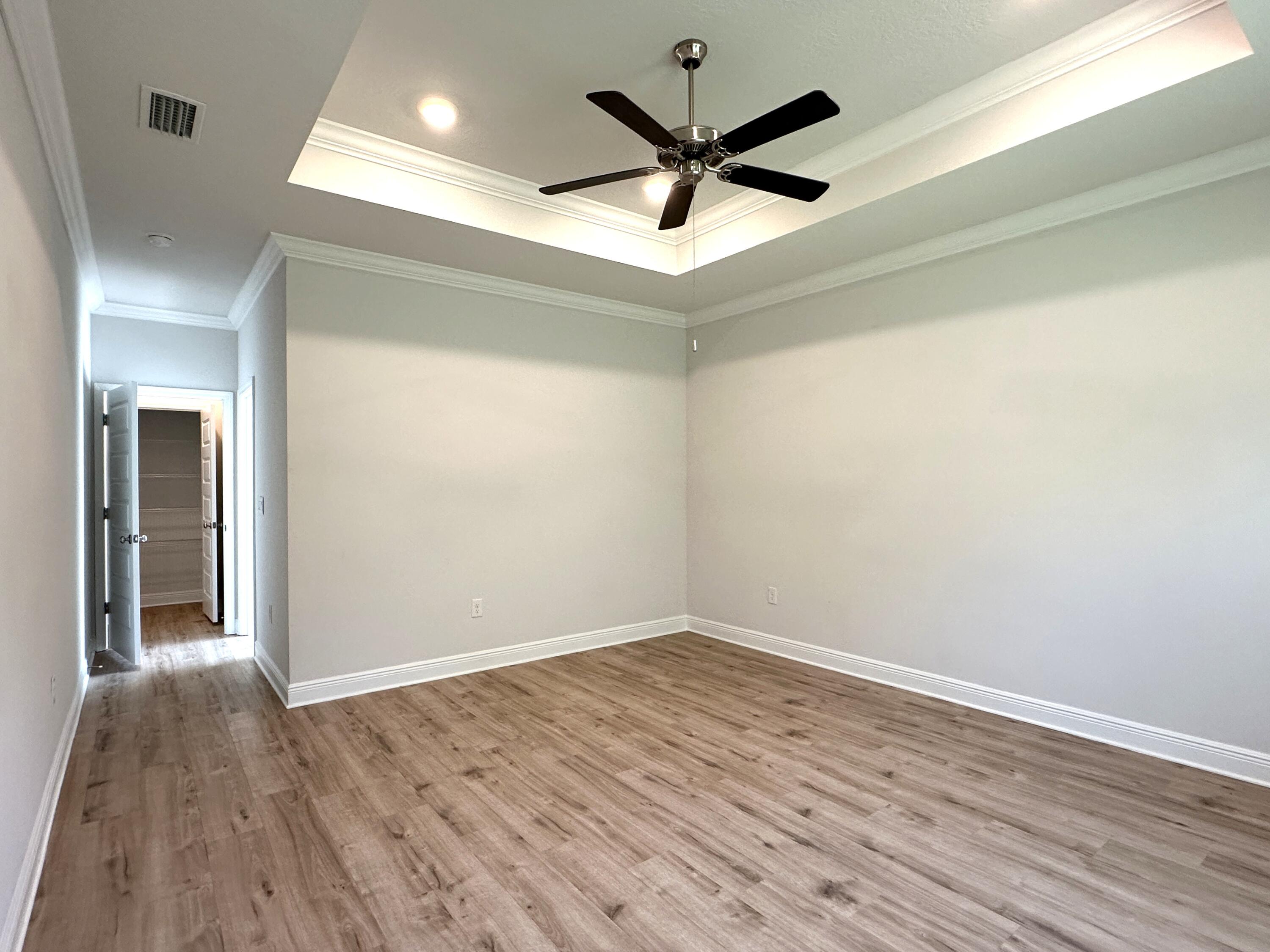 56 Secluded Circle Freeport, FL 32439 - Photo 18 of 26 an empty room with wooden floor and a ceiling fan