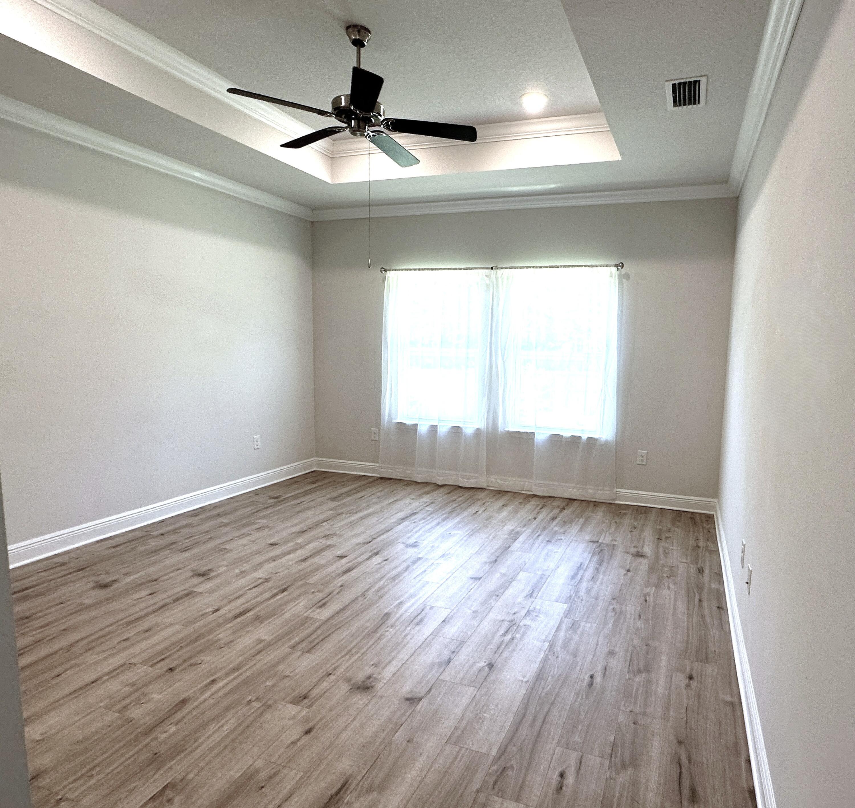 56 Secluded Circle Freeport, FL 32439 - Photo 19 of 26 an empty room with wooden floor and windows