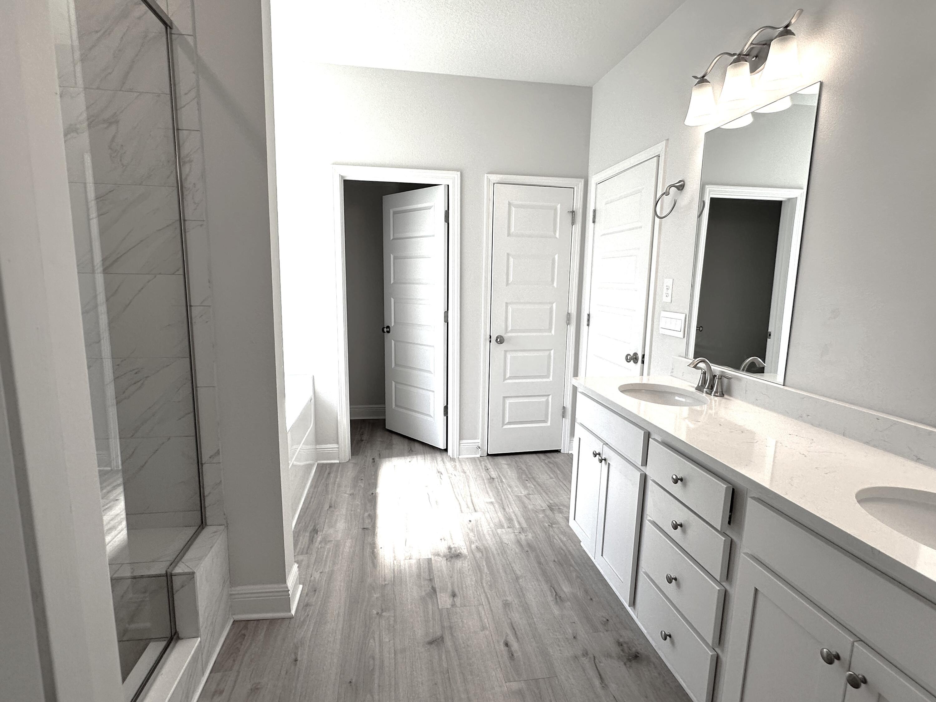 56 Secluded Circle Freeport, FL 32439 - Photo 20 of 26 a spacious bathroom with a double vanity sink a mirror and a shower