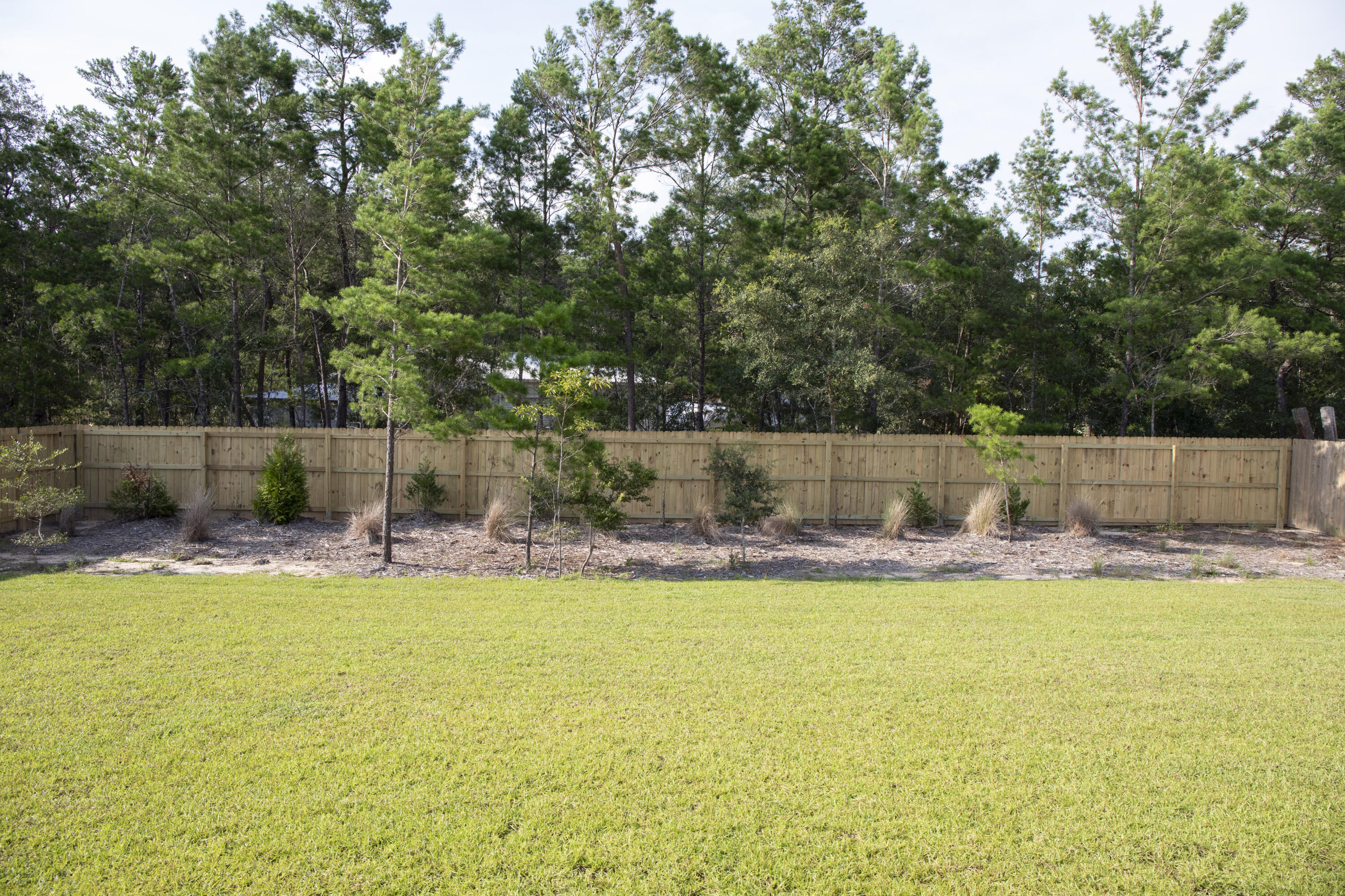 56 Secluded Circle Freeport, FL 32439 - Photo 25 of 26 a view of swimming pool with seating area and trees in the background